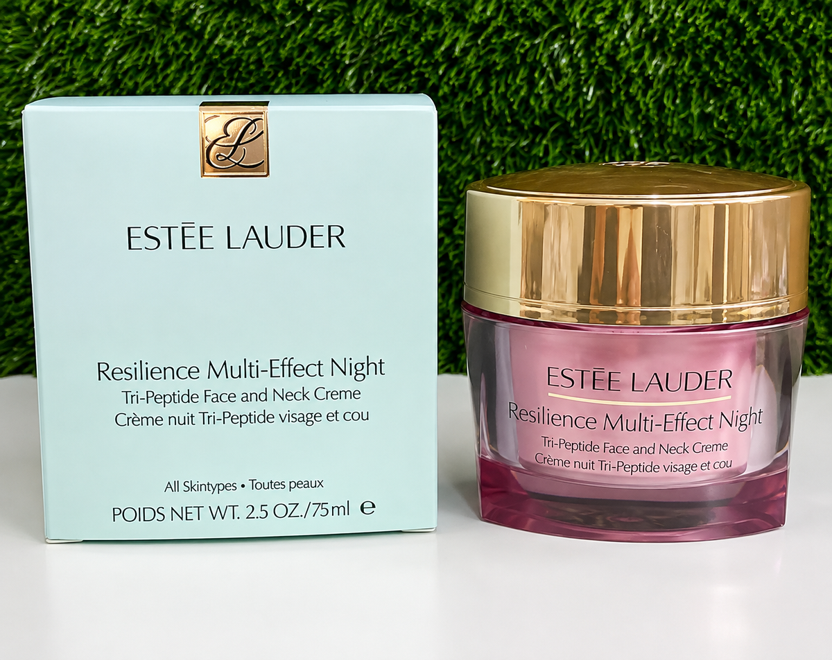 Estée Lauder Resilience Multi-Effect Night cream shown with its light blue outer box and the pink glass jar with a gold cap, set against a green grass-like background.