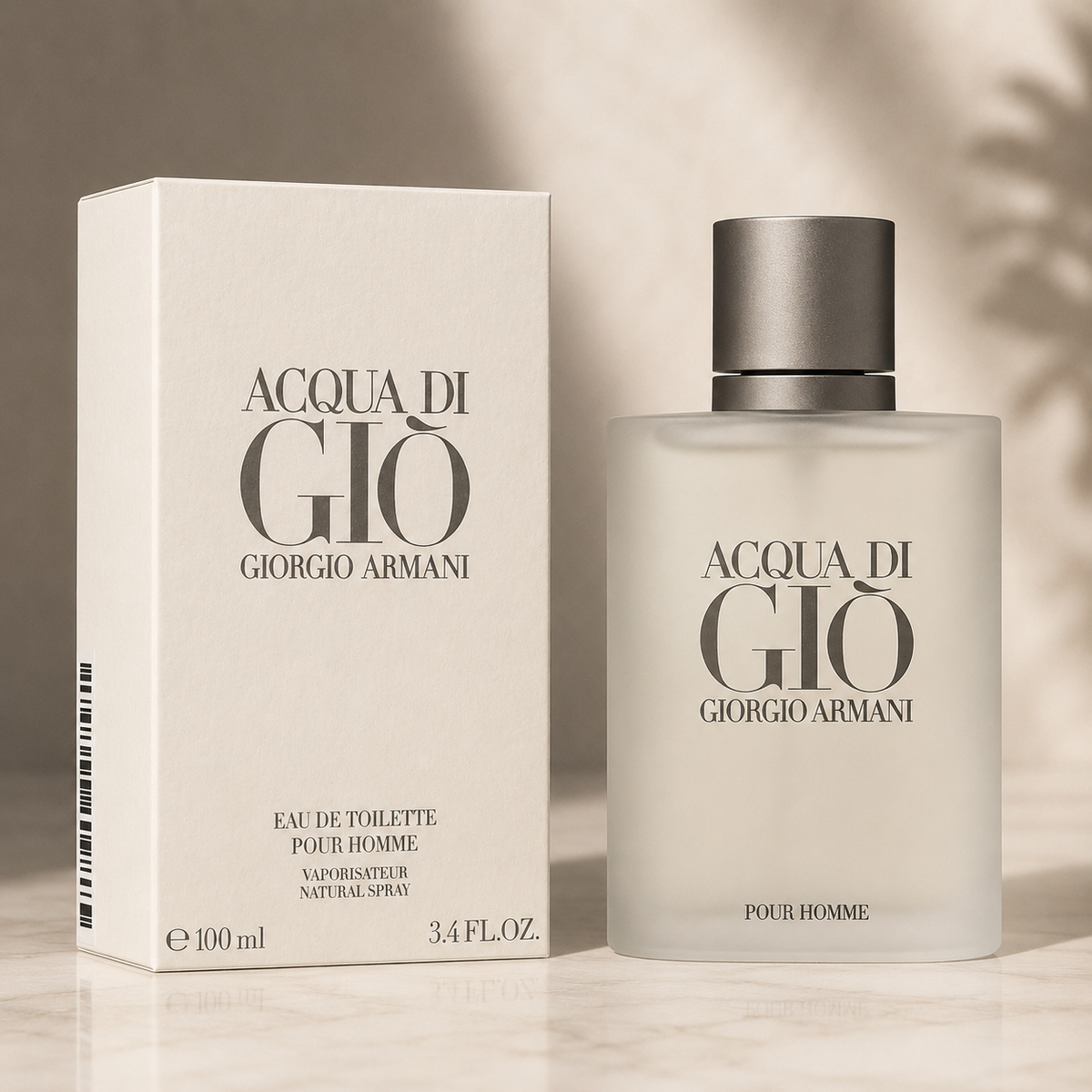 Giorgio Armani Acqua di Gio Eau de Toilette bottle and its matching box, displayed on a light marble surface with soft leaf shadows.