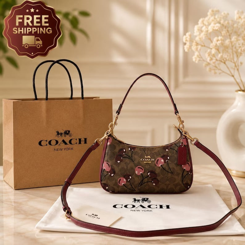 A Coach shoulder bag with a brown floral monogram pattern, burgundy leather trim, and gold hardware, displayed with a Coach shopping bag, dust bag, and a 'FREE SHIPPING' badge on a warm beige background.