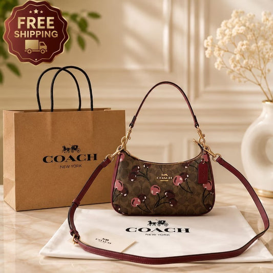 A Coach shoulder bag with a brown floral monogram pattern, burgundy leather trim, and gold hardware, displayed with a Coach shopping bag, dust bag, and a 'FREE SHIPPING' badge on a warm beige background.
