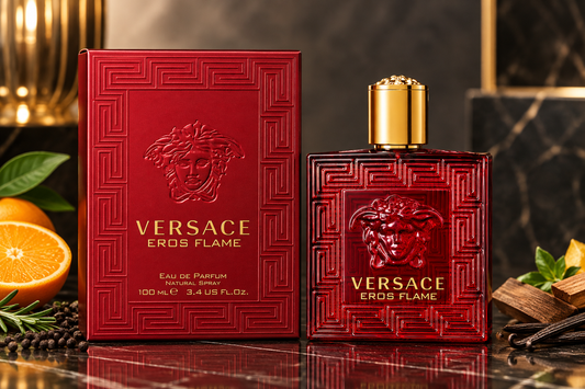 Versace Eros Flame Eau de Parfum 100ml bottle and its red packaging box, styled on a dark marble surface with citrus fruits and spices.