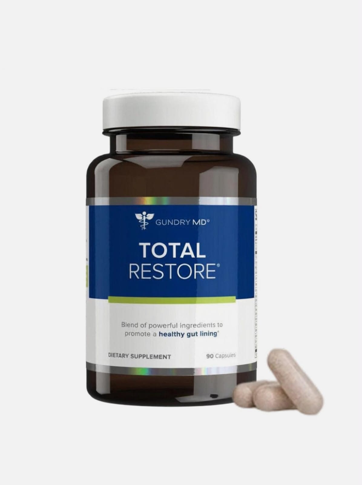 A bottle of Gundry MD Total Restore dietary supplement capsules with two capsules resting in front, set against a plain light gray background.