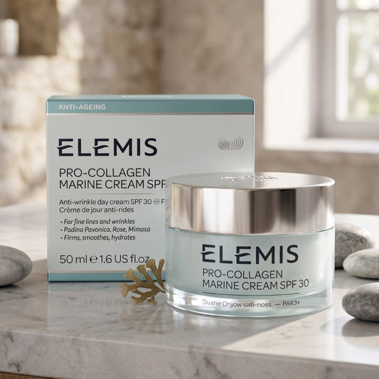 Elemis Pro-Collagen Marine Cream SPF 30 shown with its product box and jar on a marble surface. The packaging features a white and light blue design with black text.