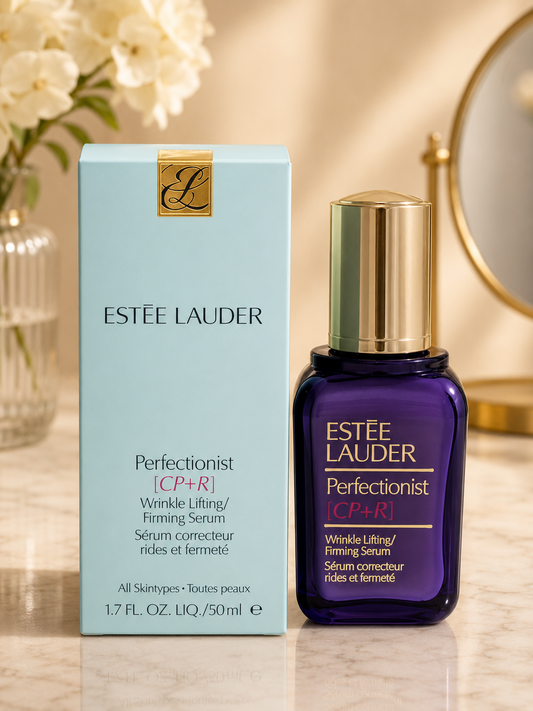 Estée Lauder Perfectionist [CP+R] Wrinkle Lifting and Firming Serum shown with its light blue box and a dark purple bottle with a gold cap on a marble surface.